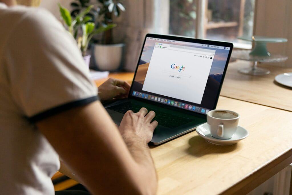 Laptop na biurku z włączoną przeglądarkę internetową i stroną Google.